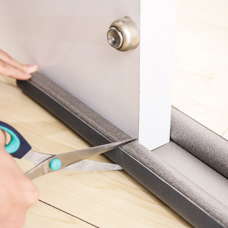 Trimming a flexible door draft stopper to fit beneath a door